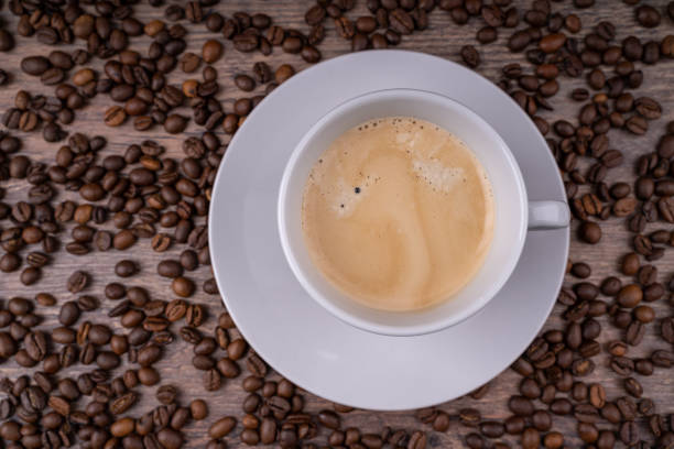 istock Fresh coffee crema in a white cup with coffee beans in the background 1463206048