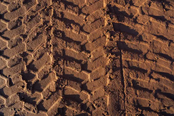 Brown sand with tire tracks from the wheel loader