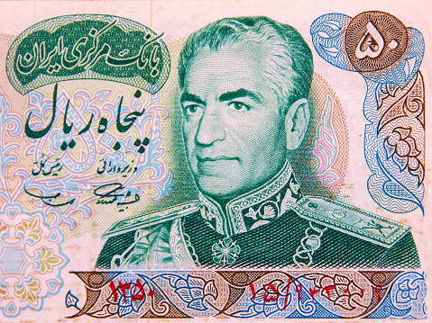 A depiction of the Shah of Iran, Reza Shah Pahlavi, on a 50 rial banknote.  The date is printed in Persian as 1350 (bottom left, in red), which means between 21 March 1971 and 20 March 1972.  In the top left corner in the area with green background is written, in the Persian language, \