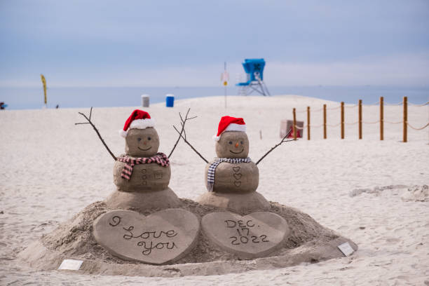 Coronado, CA - December 17, 2022: A snowman couple sand sculpture on the beach near Hotel del Coronado.