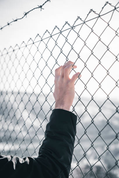istock Man hands holding barbed wire. Refugee, Freedom Concept 1463227218