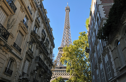 Paris, France, Sept. 26, 2018: The Eiffel Tower rises behind ornate residential buildings at the end of Rue de l'Université in Paris' 7th arrondissement.