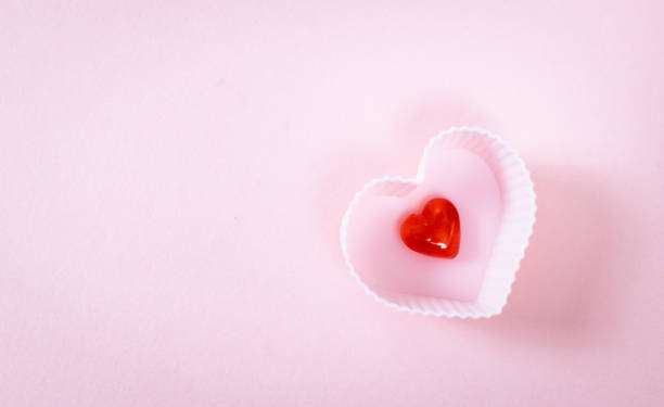 istock One muffin shape with a red heart on a pink background. 1463232404
