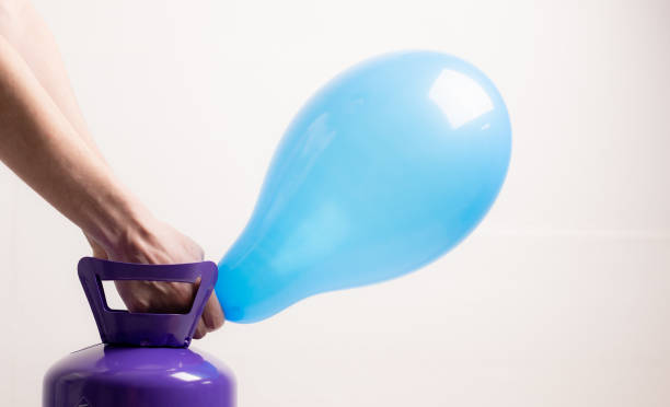 istock A young guy inflates a balloon with helium. 1463232439