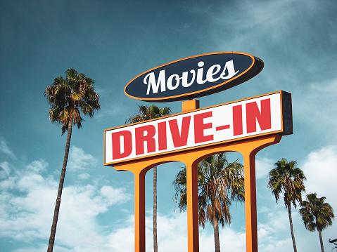 Vintage drive-in movies sign with palm trees