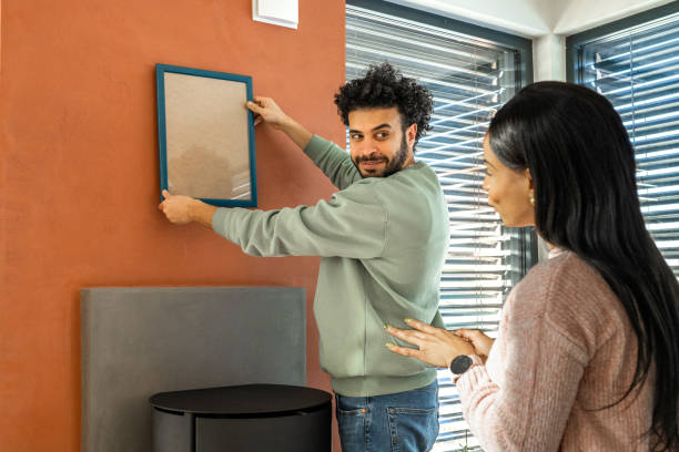 istock Couple hanging a frame on the wall 1463239400