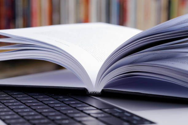 istock Close up of open book and  laptop computer at the library 1463247226