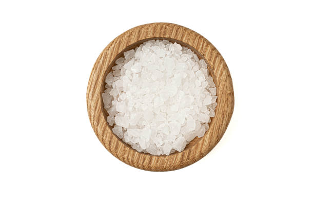 istock Salt in wooden bowl isolated on white background. 1463247620