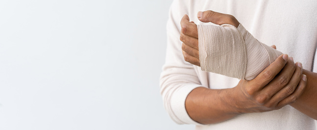 Close up of a man's leg in a cast and a blue splint after bandaging in a hospital.