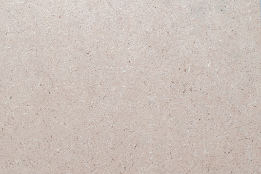 Particleboard, chipboard background with grainy texture of Medium Density Fiberboard (MDF), particle presses wooden panel or OSB Oriented strand board in light beige brown cream sepia color