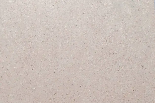 Photo of Particleboard, chipboard background with grainy texture of Medium Density Fiberboard (MDF), particle presses wooden panel or OSB Oriented strand board in light beige brown cream sepia color