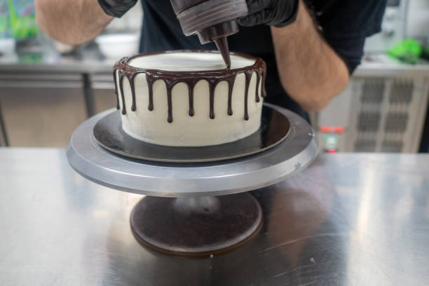 istock cake pastry chef designer decoration a dark chocolate frosted icing white cake with brown dripping with ganache filling 1463254144