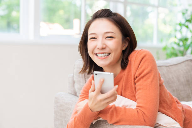 attractive Asian woman using a smart phone stock photo