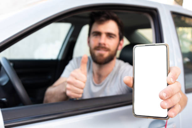 istock good looking driver showing mock up phone screen through a car window, thumbs up 1463258501