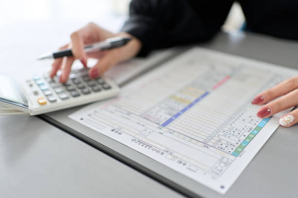 asian woman preparing tax return documents - 1040 tax form imagens e fotografias de stock