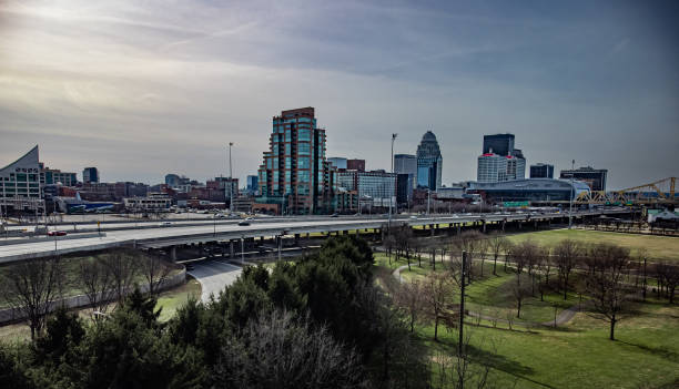 a highway situated above the waterfront park in louisville, ky, with the city skyline. - louisville kentucky kentucky skyline waterfront imagens e fotografias de stock