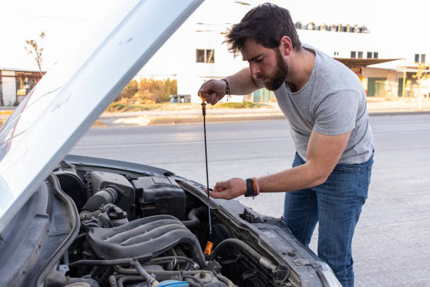 istock worried young man driver checking on the oil motor, having problems driving, car insurance concept 1463258721