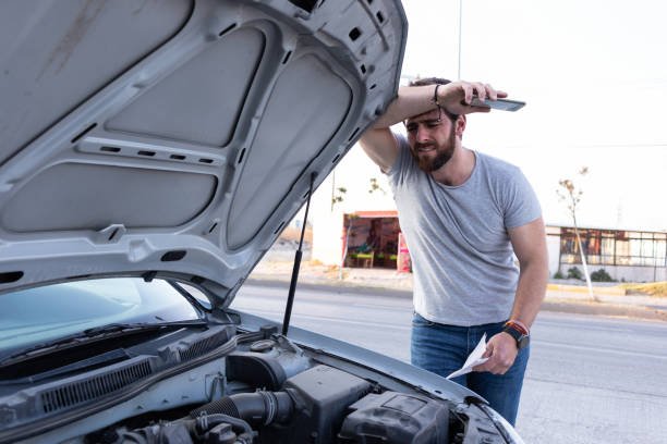 istock worried young man driver checking on the car motor, having problems driving, car insurance concept 1463258726