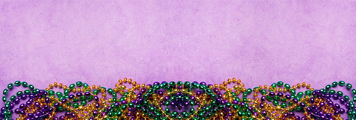 Mardi Gras beads on a purple background.