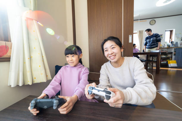 istock Young mother playing video games with her daughter 1463259952