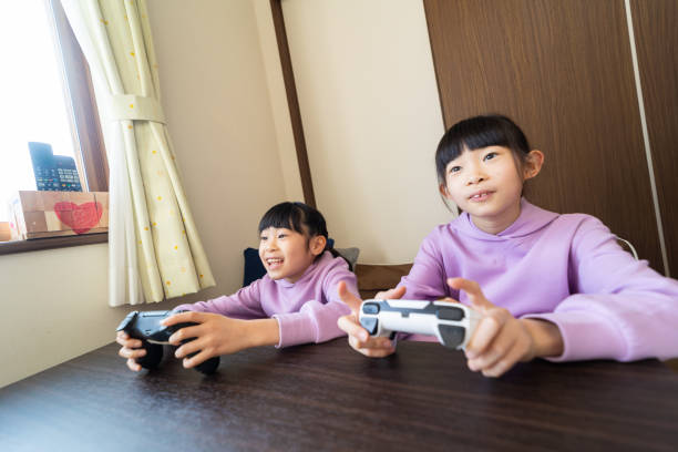 istock Two young sisters playing video games together 1463259957