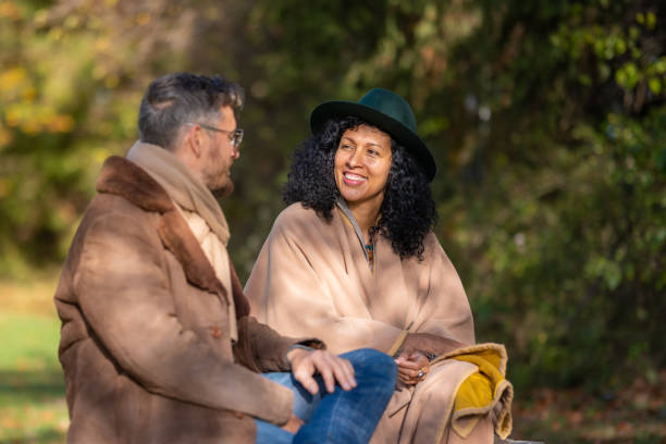 istock Two lovers are sitting on a park bench and talking. 1463260115