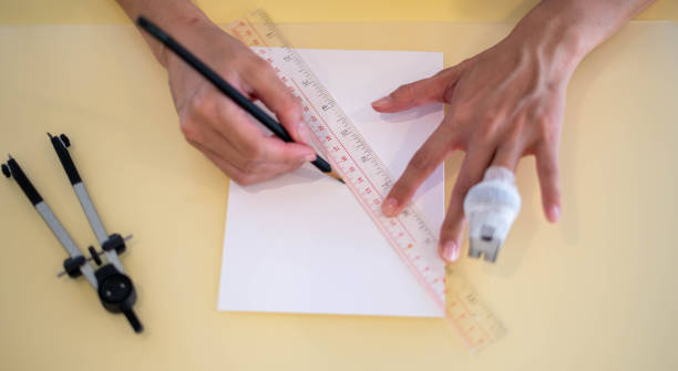 istock The female hand using a ruler with the pencil prepares to draw and sketch on the empty white paper. 1463264255