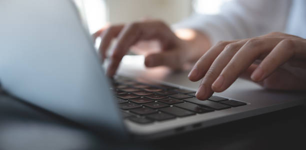 オフィスの机の上のラップトップコンピュータでタイピングするビジネスマンの手の接写、オンライン作業、インターネットネットワーキング、eビジネス、ソーシャルメディアマーケティン - connection e mail typing human hand ストックフォトと画像