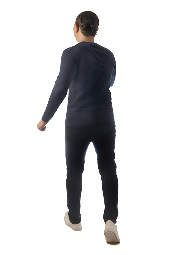 Rear view of a man wearing casual dark blue shirt black denim and white shoes, walking forward, moving with confidence. Full body portrait isolated cut out