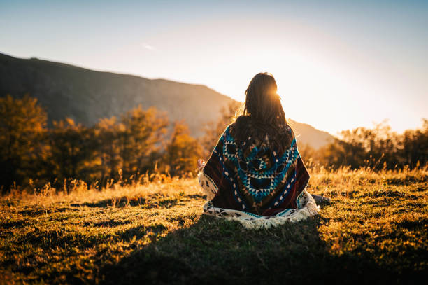 Embrace the moment! Young boho woman in the nature. Young woman watching the sunrise and meditating in the nature. native american ethnicity stock pictures, royalty-free photos & images