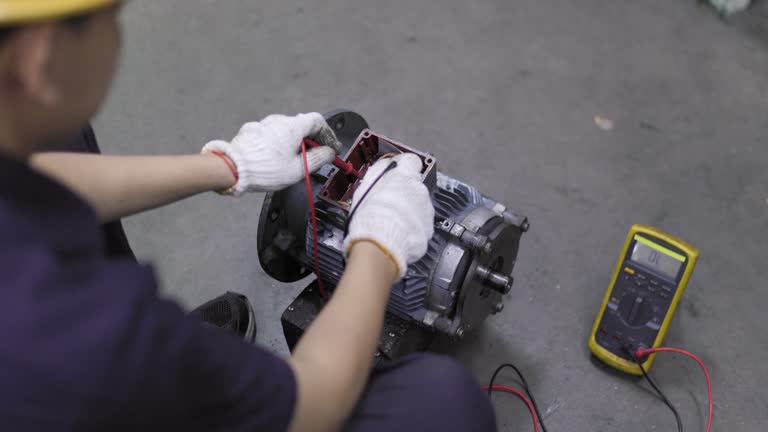 A young engineer is using a multimeter to check the winding resistance in a motor.