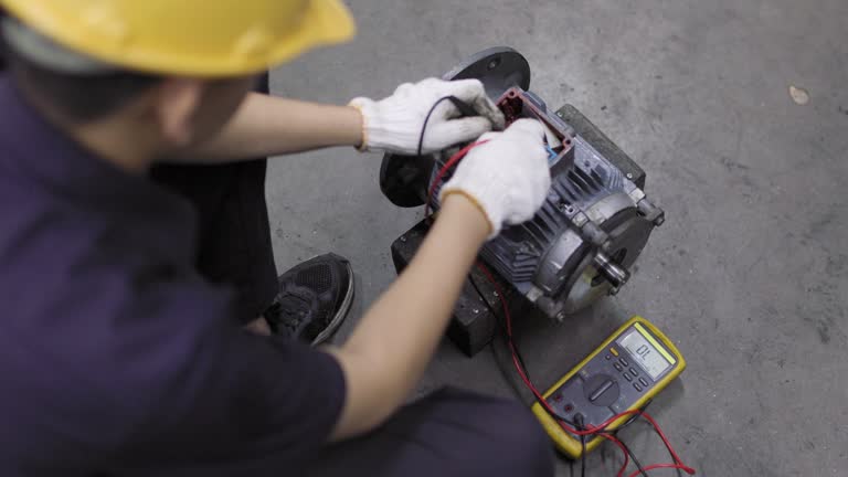 A young engineer is using a multimeter to check the winding resistance in a motor.