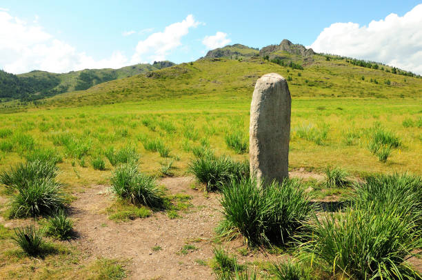 istock A triangular white granite monolith surrounded by low bushes in the center of a picturesque valley surrounded by hills. 1463280929