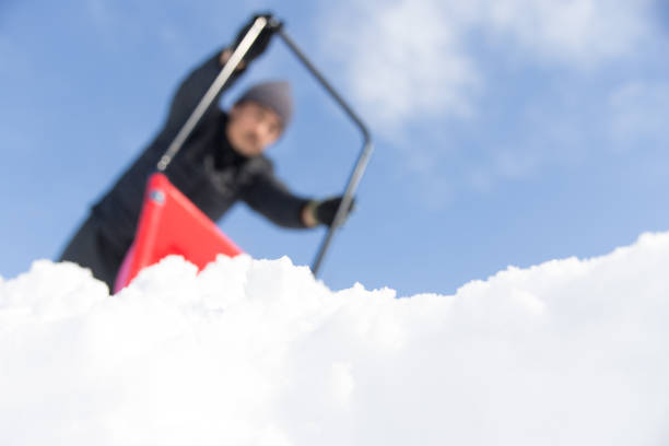 Close-up of a child's hand holding a plastic shovel and dripping snow with it. Winter fun, leisure. Hello winter