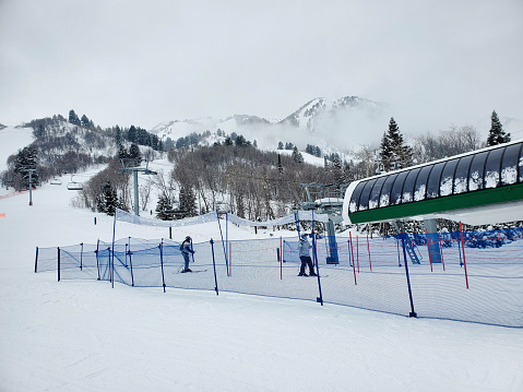 Snowbasin, Utah, USA- January 25, 2023: People and lifts at the Grizzly Center, main base of Snowbasin Ski Resort, Utah.