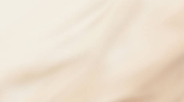 jasnobeżowe ziarniste tło gradientowe, waniliowe rozmyte tło kosmetyczne, jedwabna draperia - beige stock illustrations