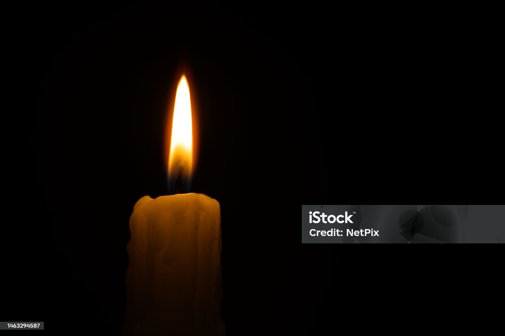 Single burning wax candle against a black background Burning candle against a black background with free copy space for text Backgrounds Stock Photo