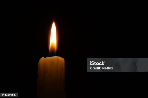 Single Burning Wax Candle Against A Black Background Stock Photo - Download Image Now