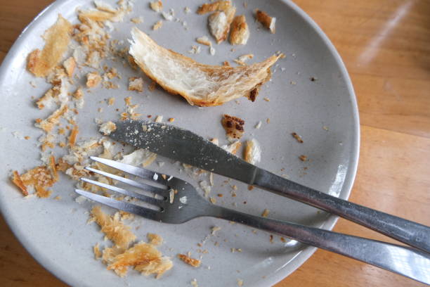 istock Dirty plate with bread crumbs, fork and knife beside. 1463298277