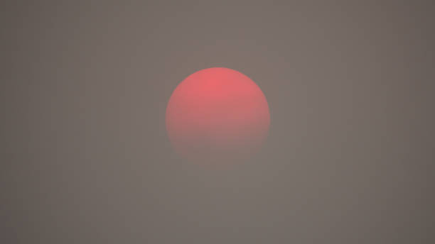 rote sonne in dicker, rauchiger, verschmutzter luft - wildfire smoke stock-fotos und bilder