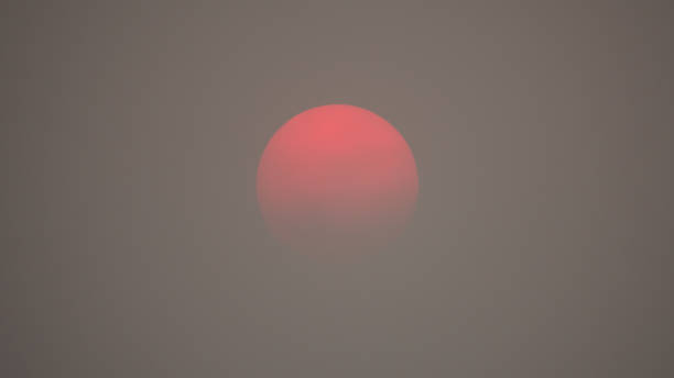 soleil rouge dans un épais air pollué enfum�é - brume de chaleur photos et images de collection