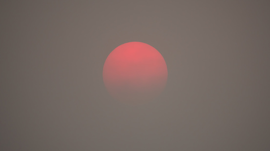 Red sun caused from air pollution smog and haze. Smoke from forest fires and environment climate change.