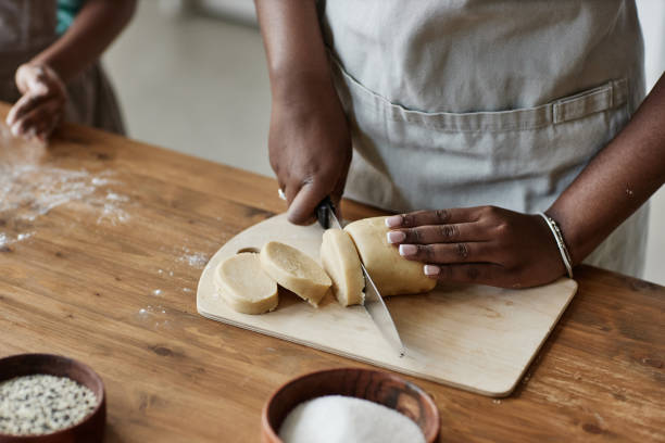 Black woman baking homemade pastry on dark wood kitchen counter