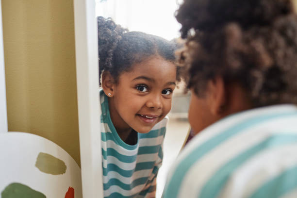 istock Close up playful black girl looking at camera in mirror reflection 1463319598