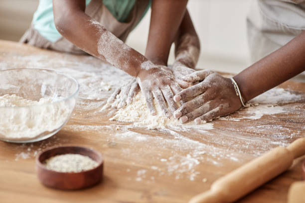 istock Mother and daughter baking together in kitchen and kneading dough 1463319628