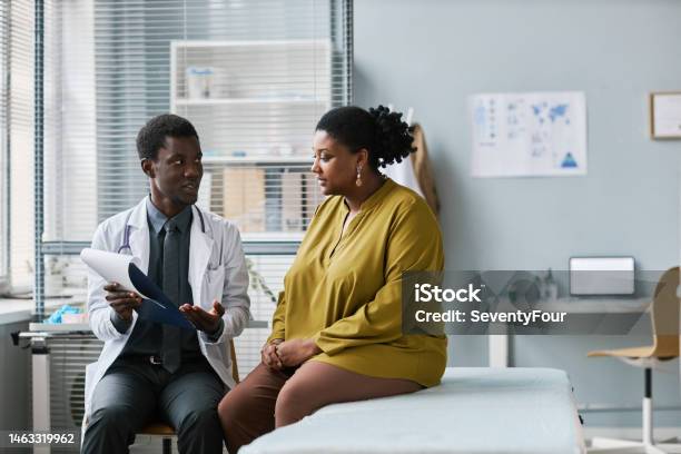 Overweight Black Woman Talking To Doctor In Medical Clinic Stock Photo - Download Image Now