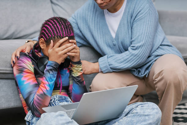 Depressed teenage girl crying on floor with mother Portrait of depressed teenage girl crying on floor with mother comforting her online bullying stock pictures, royalty-free photos & images