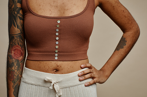 Close up of tattooed black woman posing confidently with hand on hip, real skin texture focus