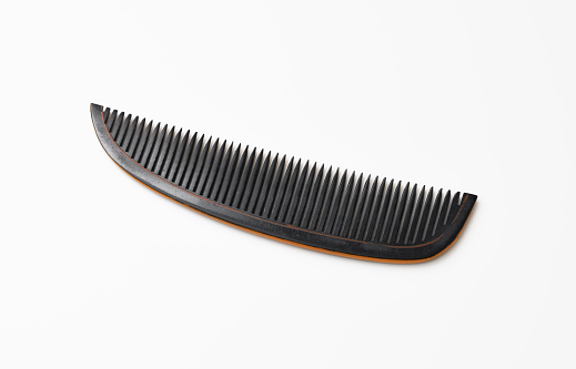 Close-up of antique Japanese comb on white background.