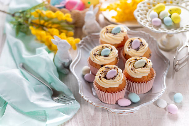 istock Homemade Easter vanilla cupcakes bird's nest with butter cream, chocolate and candy eggs on a dish. 1463336163